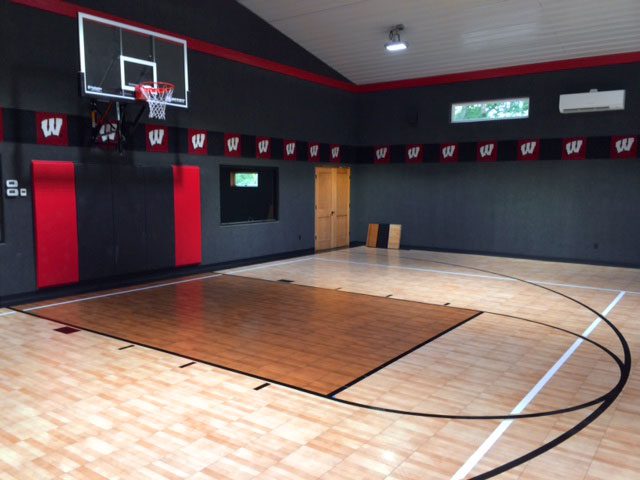 A residential indoor basketball court in a home gym.